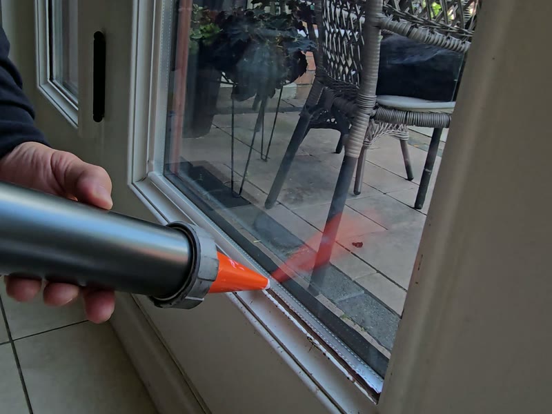 White structural silicone anchoring security film to a white window frame