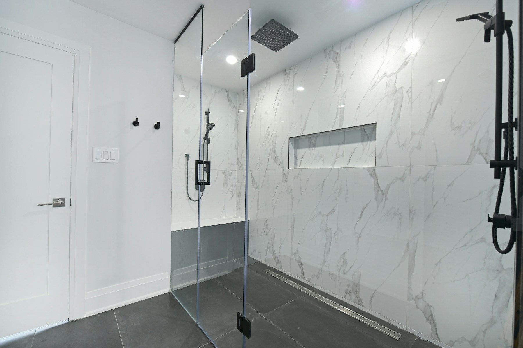 Bathroom with marble walls and a glass shower